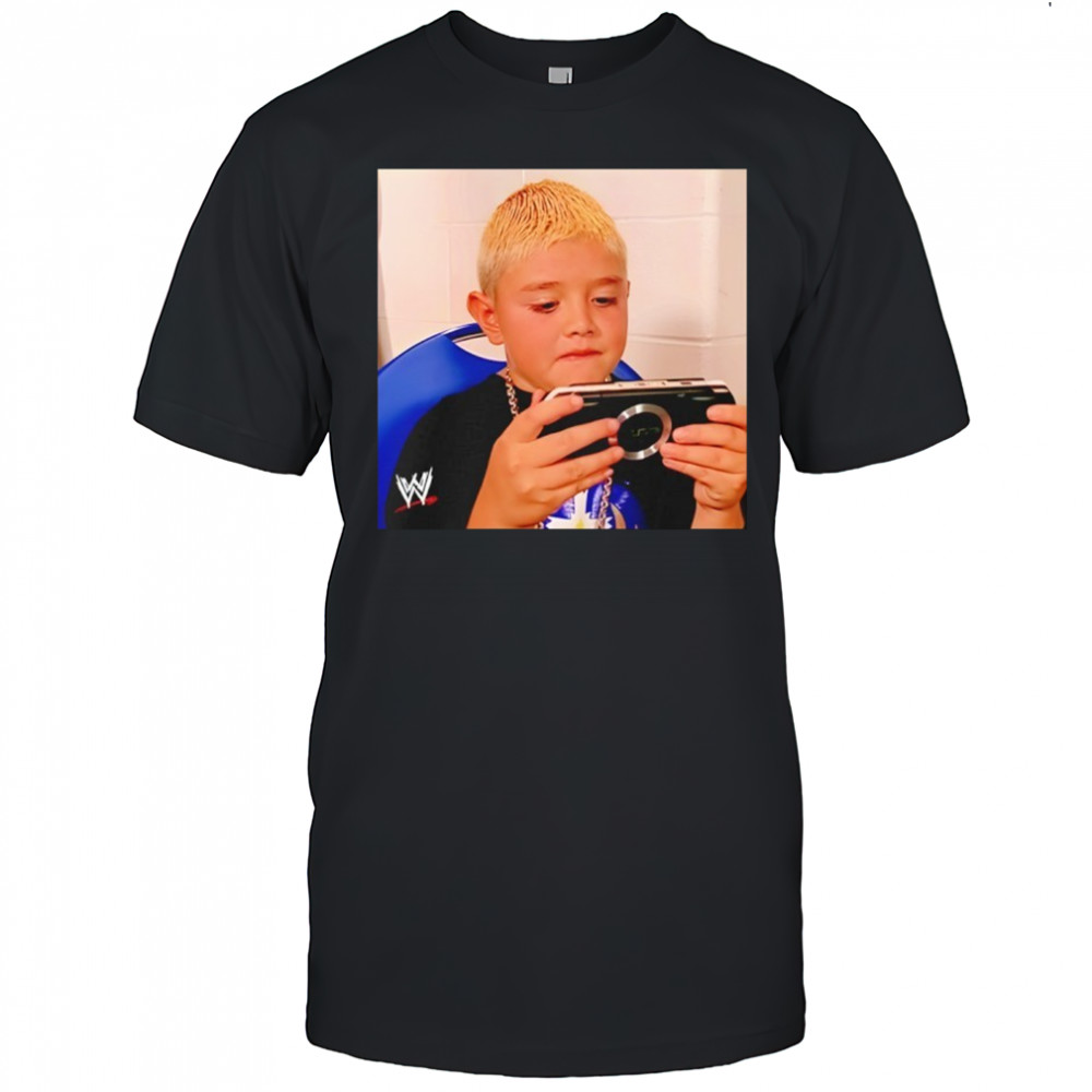 Dominik Mysterio wearing his younger self playing the PSP shirt